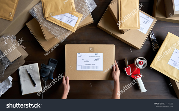 A lady warehouse staff doing order fulfillment in house, packing parcels before shipping them out