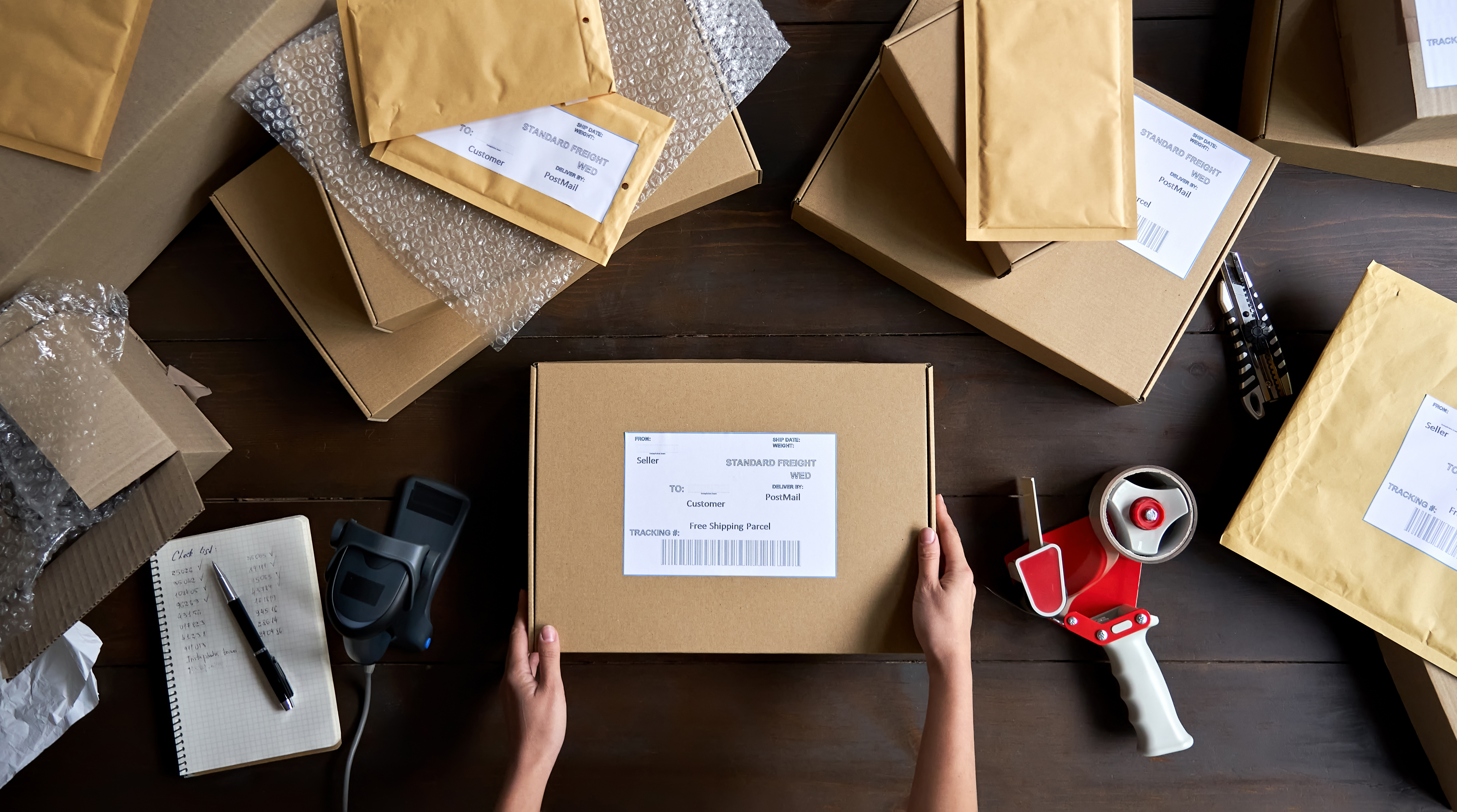 A lady warehouse staff doing order fulfillment in house, packing parcels before shipping them out