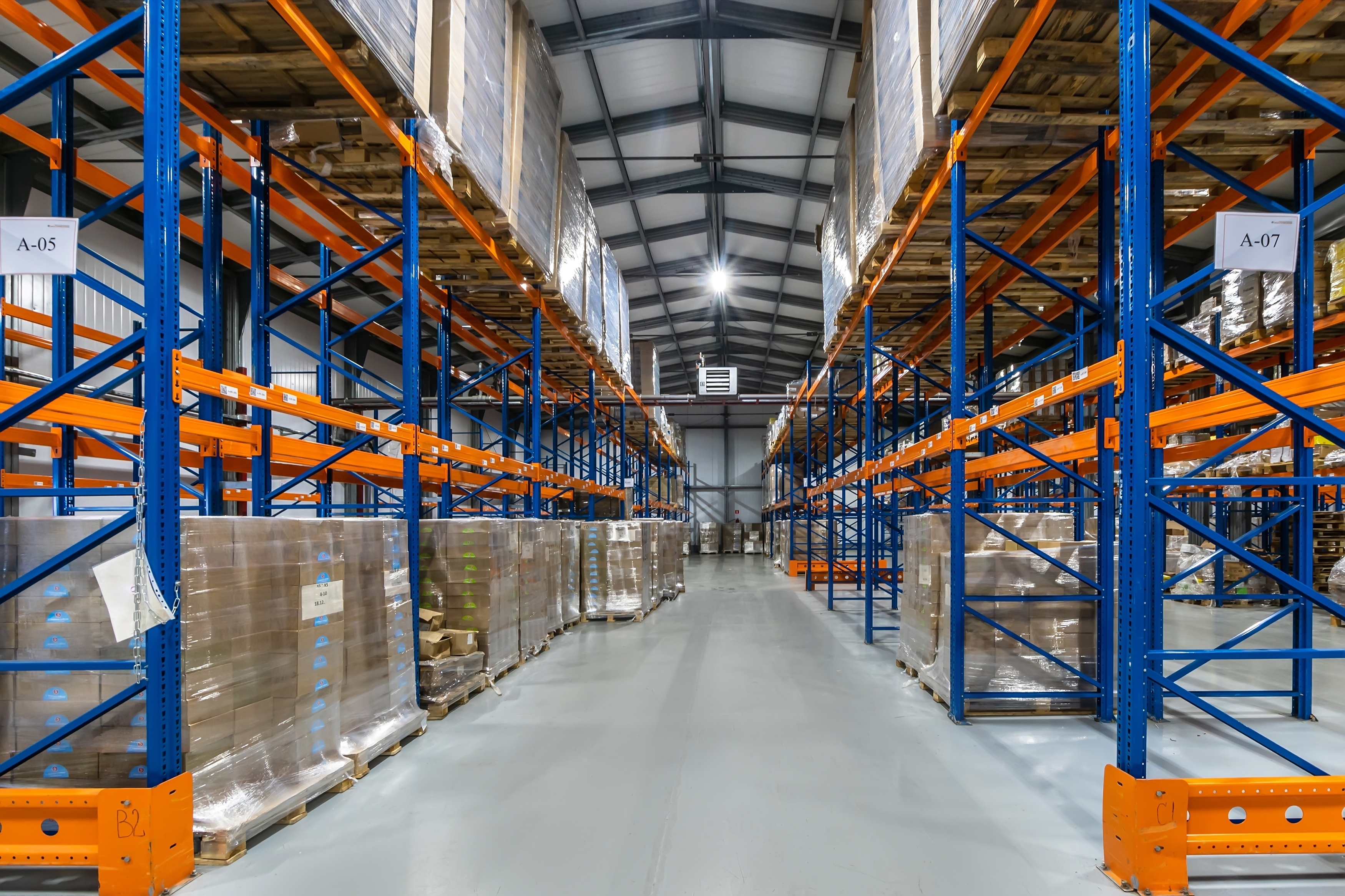 Warehouse with blue and orange shelves. A warehouse and shelving are some infrastructure required with order fulfillment