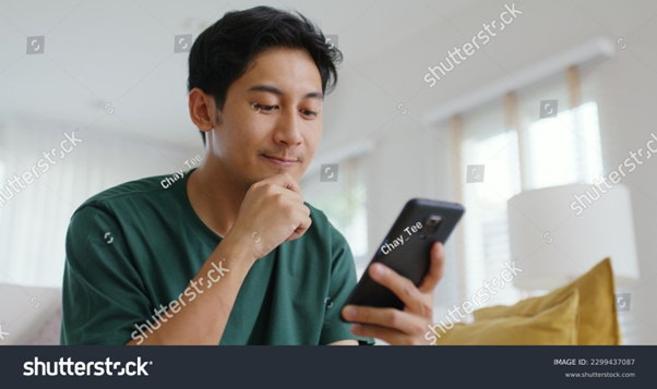 Man scrolling through his phone, likely browsing an online shop. Multiple sales channels can provide multiple touch points for customers